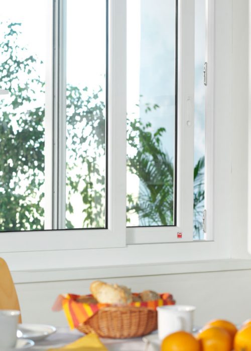 Finestra scorrevole in PVC bianco installata in cucina luminosa e moderna